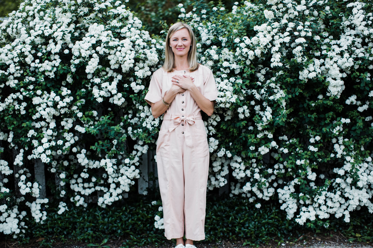 Kelli Mix standing in front of white flowers